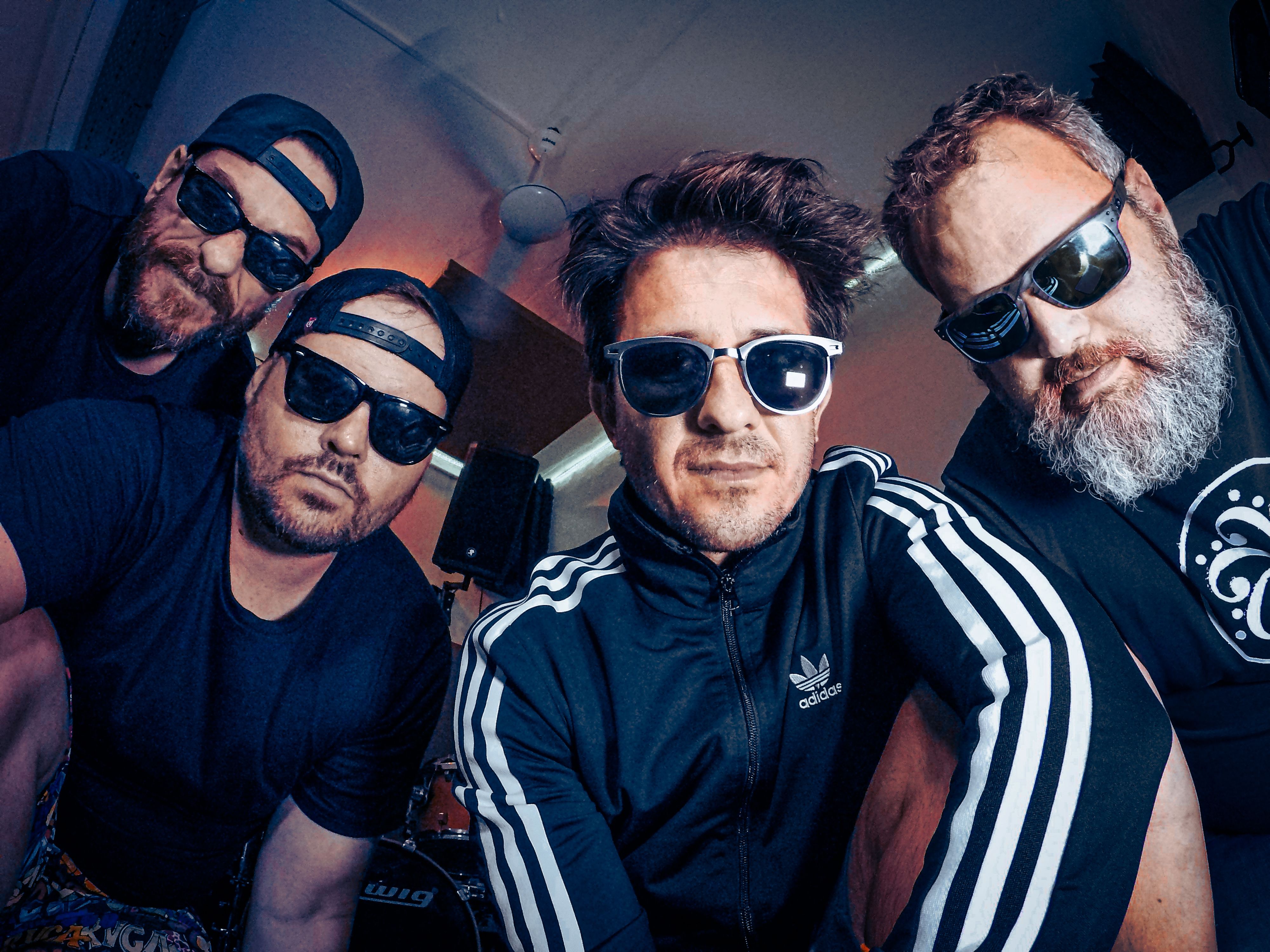 The four current members of Ill System wearing sunglasses in their rehearsal room